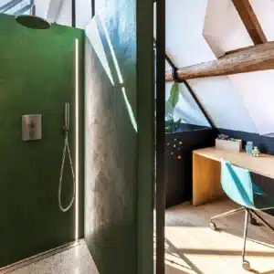 Salle de bain avec murs et sol en béton ciré coloré, lavabo intégré, douche à l’italienne et mobilier minimaliste, ambiance moderne et lumineuse.