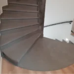 Escalier tournant avec palier en béton ciré gris Rouvière Collection, intérieur moderne et antidérapant