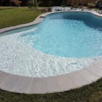Margelles modèle Grésé Gris Berg recoupées sur mesure pour une piscine courbe en Haute-Garonne.