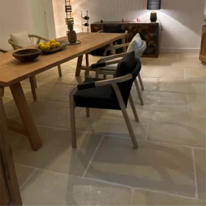 Carrelage modèle Bastide en teinte pierre dans un salon, sol effet pierre naturelle au style authentique.