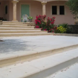 Escalier extérieur en pierre couleur naturelle, élégant et luxueux, maison provençale aux volets verts.