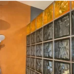 Béton ciré BC-14 Abricot associé à des briques de verre orangées New Color, intérieur lumineux et design contemporain.