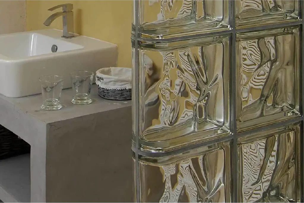 Paroi en briques de verre transparentes Rouvière Collection avec finitions arrondies, salle de bain moderne et naturelle, design haut de gamme