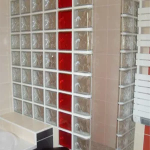 Douche avec paroi transparente neutre et détails rouges Bril, salle de bain moderne et design.