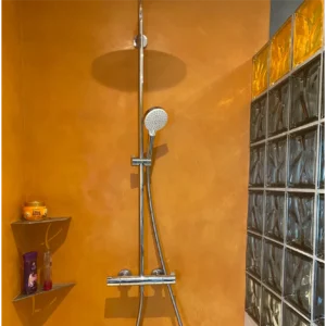 Salle de bain moderne en béton ciré teinte abricot, finition Rouvière Collection.