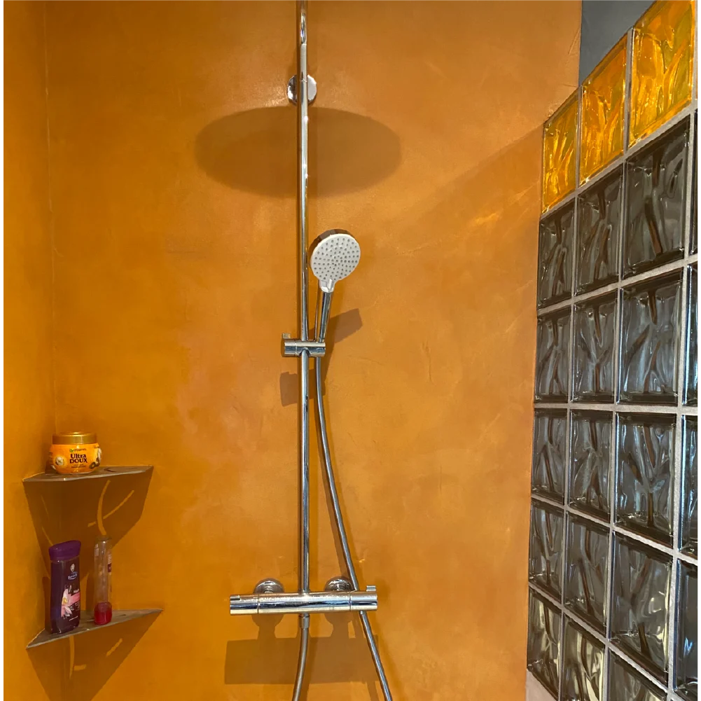 Salle de bain moderne en béton ciré teinte abricot, finition Rouvière Collection.