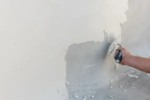 Application de la première couche de béton ciré Rouvière Collection sur un mur