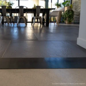 Détail du grain d’un dallage bouchardé gris Rouvière Collection dans un intérieur contemporain de style industriel