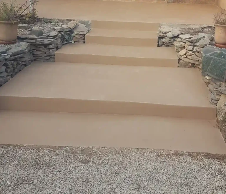 Escalier extérieur quatre marches en béton ciré avec habillage de cailloux
